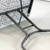 6' x 30" Resin Banquet Table, close-up view of the metal frame and leg support structure on a tiled floor.