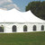 8' x 30' Cathedral Window Sidewall, large white event tent with multiple arched window panels set outdoors on grassy field under a partly cloudy sky.