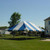 Celina Tent 20' x 30' Classic Series Pole Tent, 1 Piece Tent Top, Complete, outdoor event tent with blue and white striped canopy set up on a grassy lawn.