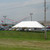 Celina Tent 20' x 40' Classic Series Pole Tent, 1 Piece Tent Top, Complete, outdoor event tent set up on a grassy area with vehicles and a firework display in the background.