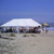 Celina Tent 20' x 40' Classic Series Pole Tent, Sectional Tent Top, Complete, outdoor beach event setup with white tent on sandy beach, with guests and chairs underneath.