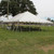 Celina Tent 30' x 45' Classic Series Pole Tent, Sectional Tent Top, Complete, outdoor event tent set up on grassy field with trees and sky in the background.