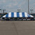 Celina Tent 30' x 60' Classic Series Pole Tent, Sectional Tent Top, Complete, with blue and white striped canopy set up in a parking lot.