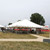 Celina Tent 40' x 60' Classic Series Pole Tent, Sectional Tent Top, Complete, set up outdoors with supporting poles and stakes on a grassy field for events or gatherings.