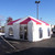Celina Tent 20' x 20' Master Series Frame Tent, 1 Piece Tent Top, complete, white and red striped event tent set up outdoors in a parking lot with clear blue sky.