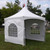 Celina Tent 10' x 10' Pinnacle Series High Peak Frame Tent / Cross Cable Marquee, complete, outdoor event tent with high peak roof and side walls, set up in a grassy area with trees in the background.