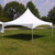 Celina Tent 20' x 20' Pinnacle Series High Peak Frame Tent / Cross Cable Marquee, complete, outdoor event tent with a high peaked roof and sturdy frame, set up on a grassy field with trees in the background.