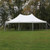 Celina Tent 20' x 30' Premiere I Series High Peak Pole Tent, 1 Piece Tent Top, Complete, white high peak pole tent set up outdoors on grass with a backdrop of trees.