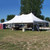 Celina Tent 20' x 40' Premiere I Series High Peak Pole Tent, 1 Piece Tent Top, Complete, white outdoor event tent set up on grass with support poles and trees in the background.