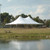 Celina Tent 30' x 45' Premiere I Series High Peak Pole Tent, Sectional Tent Top, Complete, set up outdoors with a pond in the foreground and trees in the background.