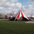52' TP Series Hexagon Tent, Complete, outdoor event tent with red and white striped canopy set up on grassy area.