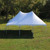20' x 30' Master Series High Peak Frame Tent, 1 Piece Tent Top, Complete, outdoor event tent set up on grassy field with trees in the background.