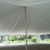 Pole Tent Liner 40' x 20' Mid, interior view showing the white fabric of the tent liner and supporting pole, set up outdoors with a garden landscape visible in the background.
