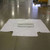 60" x 100" Wrap Around Bag, large white plastic wrap spread out on the floor with a smaller white package in the center.