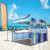 10' Full Print Fast Shade Backdrop, colorful beach scene with turquoise sky, white sand, and a striped tent.