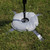 Flag Water Weight Bag, outdoor grass field with a circular water-filled weight bag and adjustable flag pole for stability during events or training.
