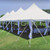 7' x 40" Leg Drape with Sash, white event tent with draped legs and sashes on a grassy outdoor setting under blue sky.