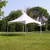 15' x 15' Pinnacle Series, White Cross Cable Tent, Complete, showing a large white tent with a peaked roof and open sides set up outdoors on grass, surrounded by trees in the background.
