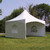 15' x 15' Pinnacle Series White Cross Cable Tent, complete outdoor event tent set up on grass with trees in the background.