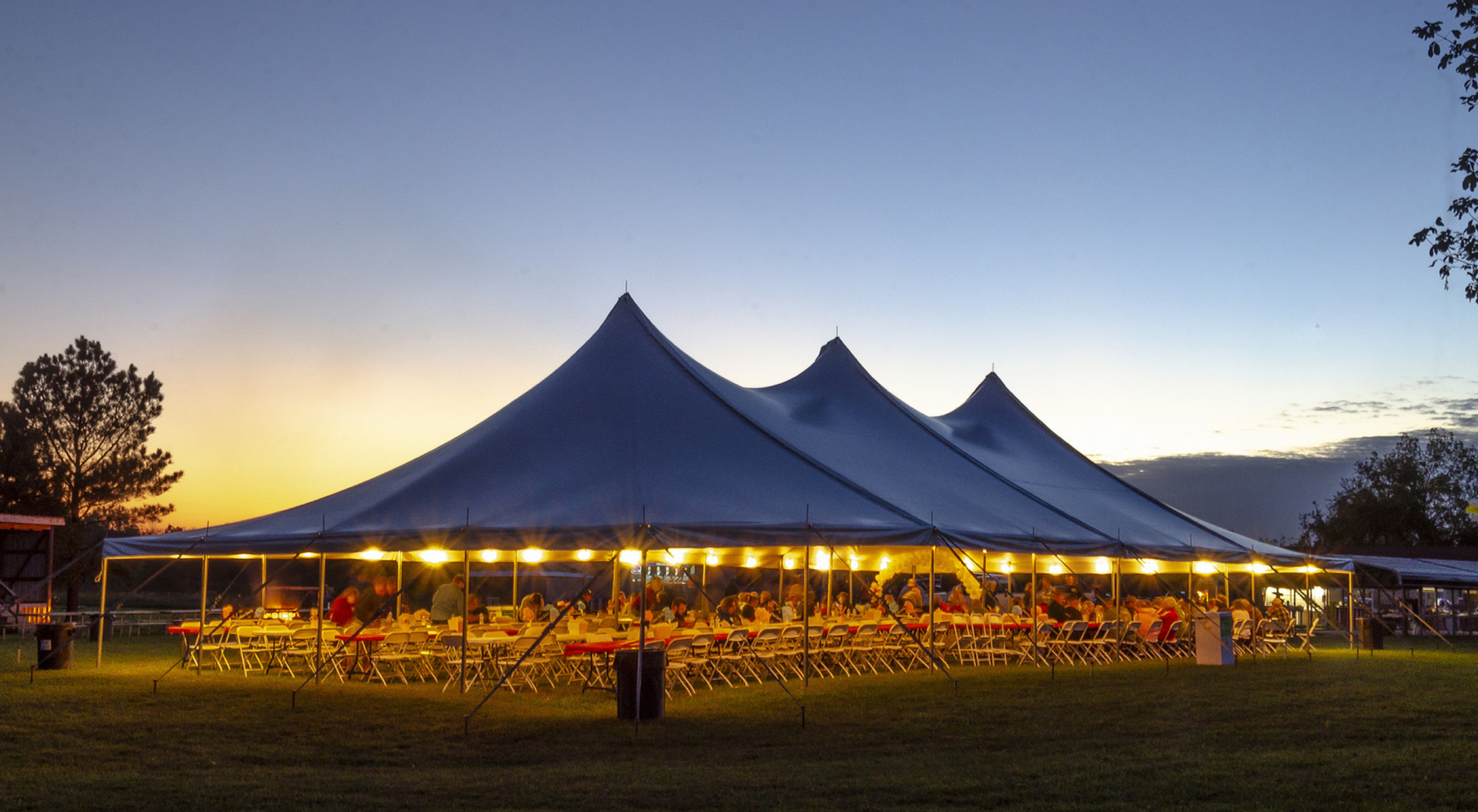 Large wedding party tent with evening lighting