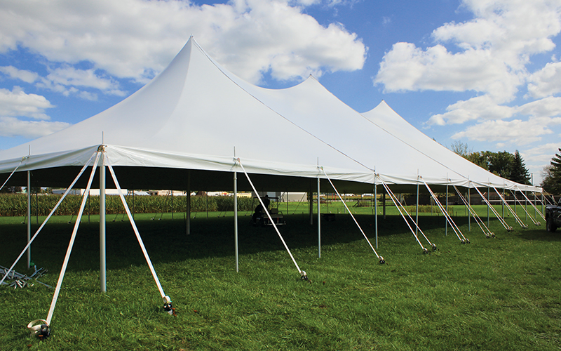 Graduation party tent setup with tables and decorations