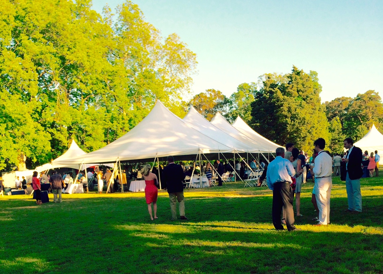 Outdoor party tent setup with seating and lighting for a comfortable event layout