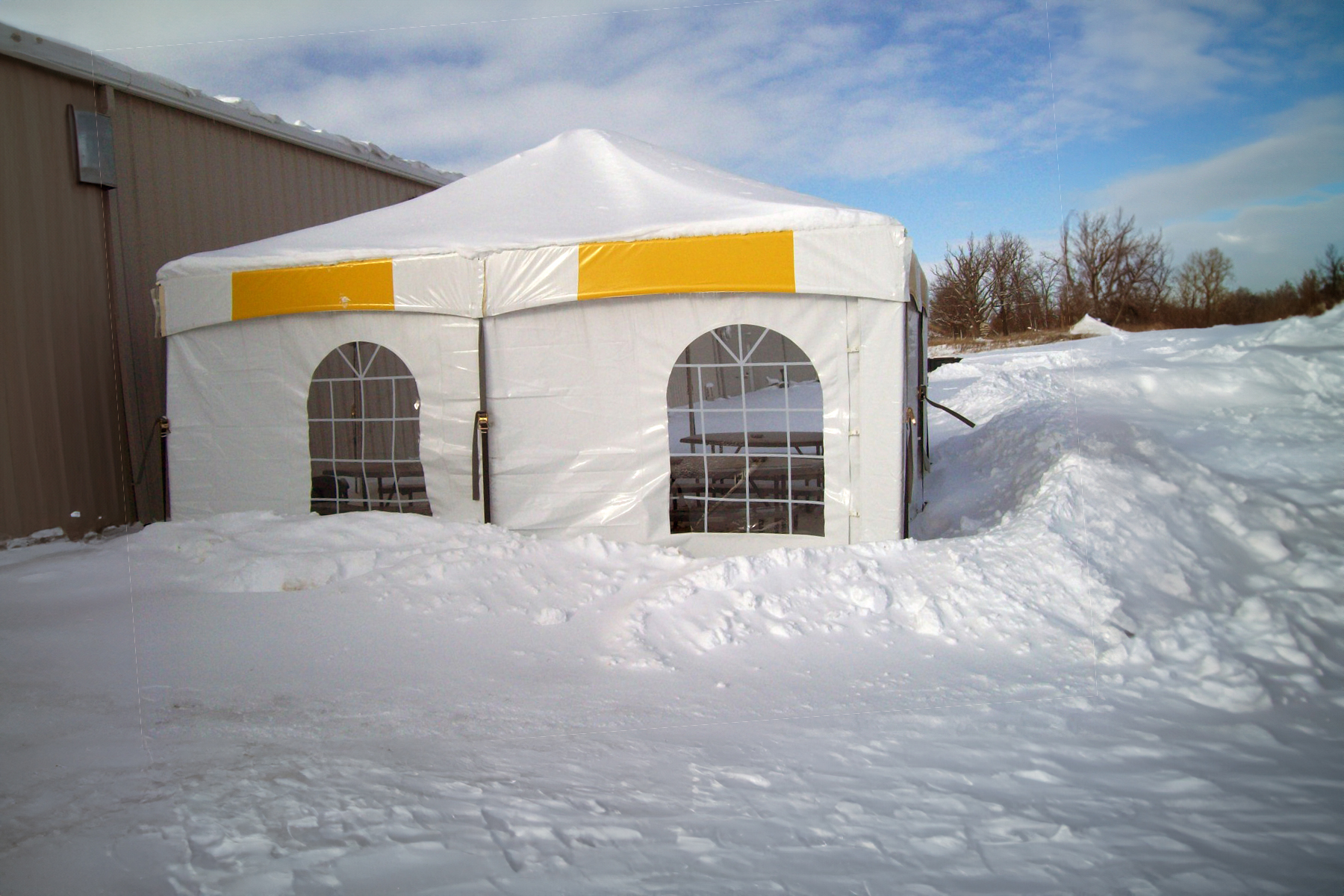 Tent sidewalls installed on an event tent to block wind and rain while keeping the setup professional