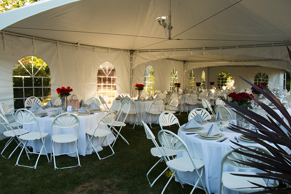 Stacks of wholesale party chairs and folded tables prepared for event rental inventory and quick setup