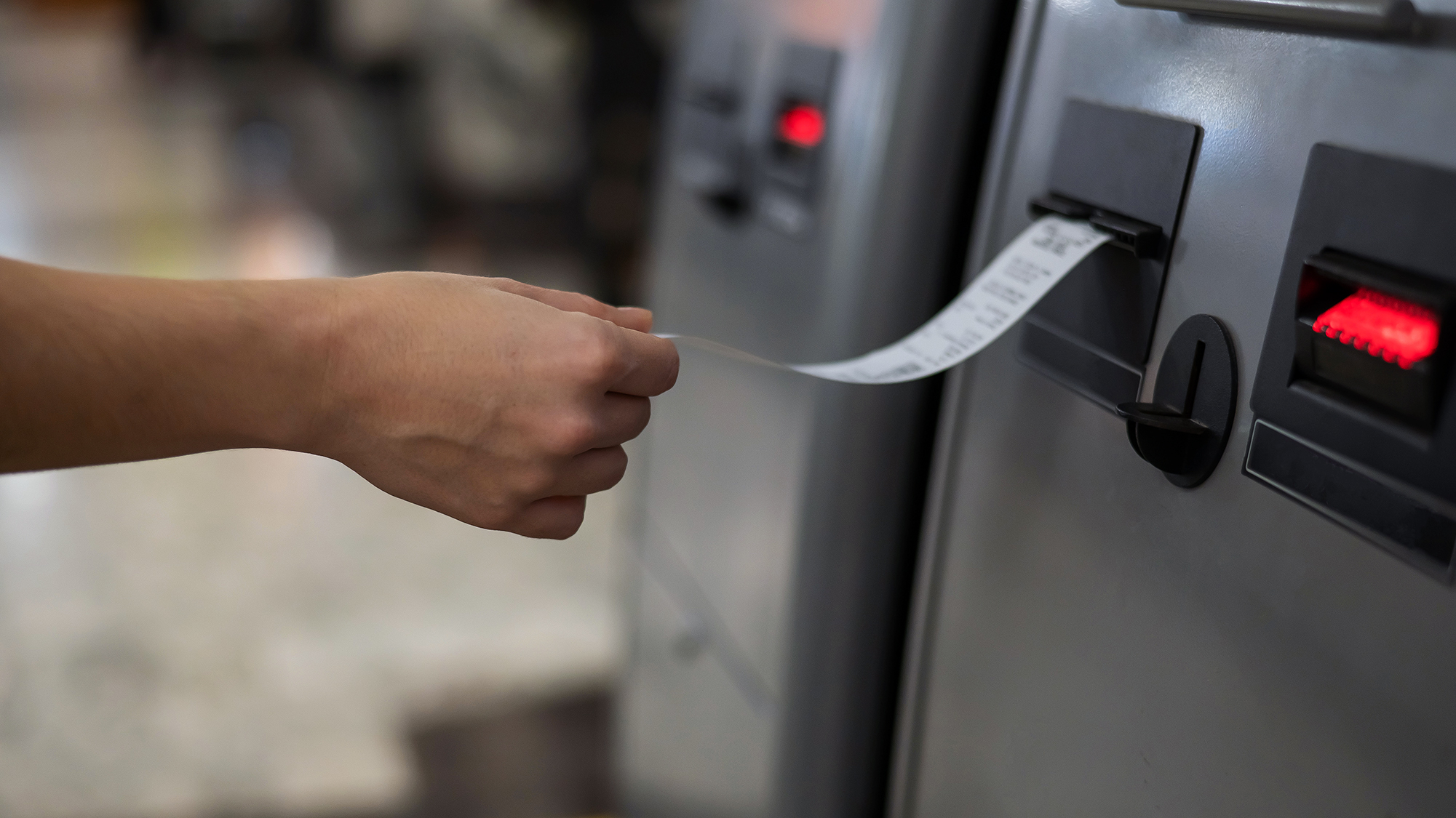 Woman takes receipt from ATM after transaction