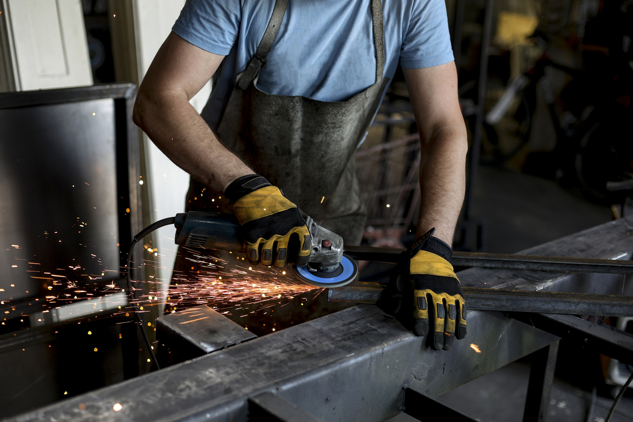 Using Pferd CC Grind System - A male metalworker using a grinding tool to cut metals.