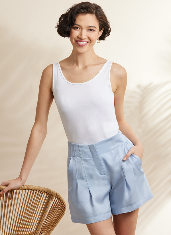 Woman in white tank top and light blue shorts