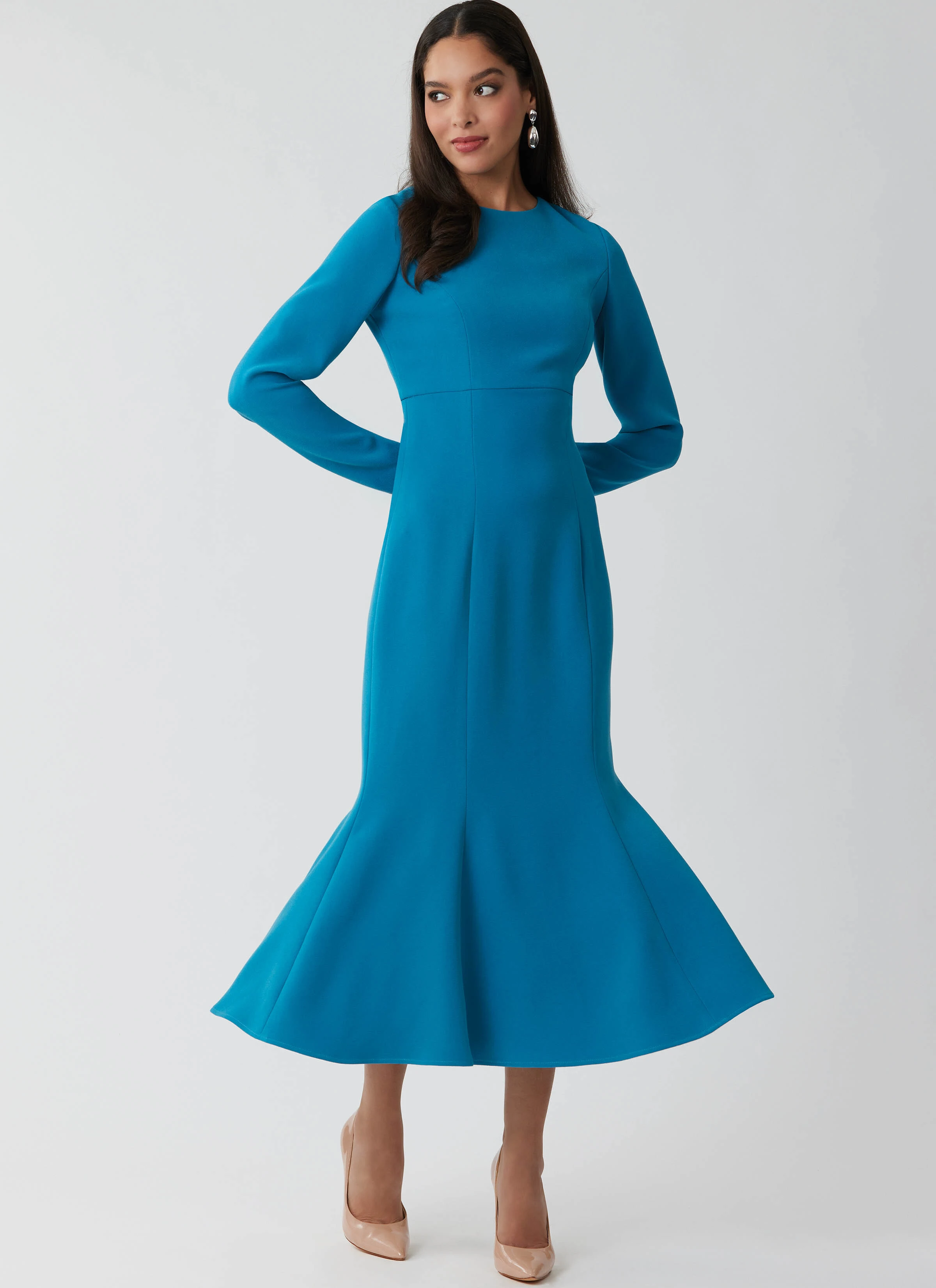 Model wearing a teal calf length dress with flared hem.