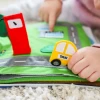 The Fabric Activity Book - Away We Go is a Montessori inspired quiet book featuring travel, camping and transport activities that build fine motor skills, imagination and independent learning.