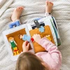 The Fabric Activity Book - Away We Go is a Montessori inspired quiet book featuring travel, camping and transport activities that build fine motor skills, imagination and independent learning.