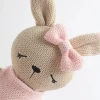 Meet Bella the Bunny, a soft 100% cotton knitted comfort toy with embroidered details, pink dress and bow. Perfect for cuddles, sensory play and gifting.