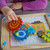 Go Go Gears is an engaging and educational wooden puzzle that introduces children to the fascinating world of gears and encourages various developmental skills.