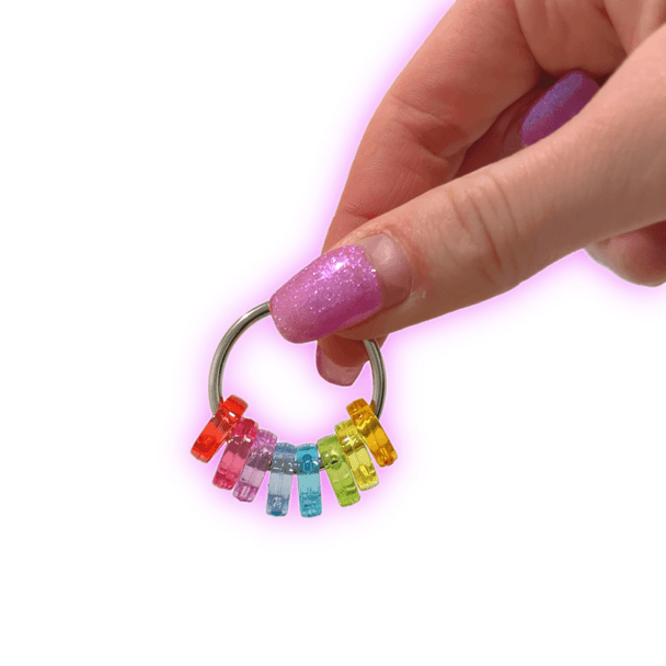 Dinky Things Fidgets - Rainbow Roller has a bunch of smooth rainbow beads that effortlessly glide along your fingers & have lots of room to spin around the ring
