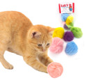orange kitten playing with pink real rabbit fur pom cat toy with package in the background