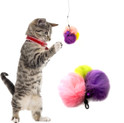 gray striped kitten on its hind legs playing with a 3 pom real rabbit fur handmade teaser with bell, pink, yellow, purple