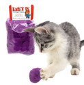 white and gray kitten batting a real rabbit fur jumbo purple pom with a package in the background