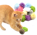 orange kitten playing with pink real rabbit fur pom cat toy with package in the background