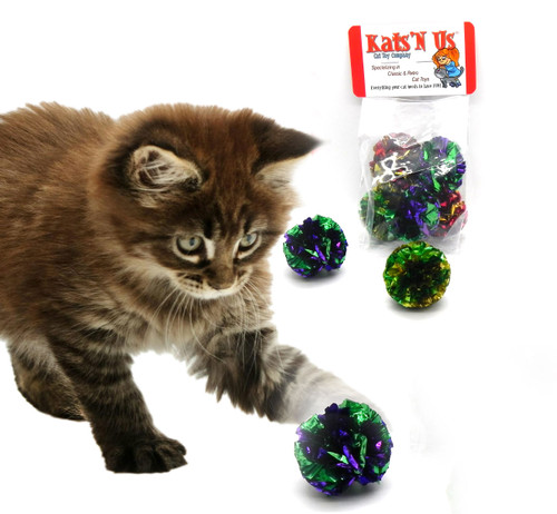 tabby kitten batting a mylar crinkle sparkle cat toy ball with a package in the background