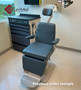 Reliance 980 ENT procedure chair refurbished with gray upholstery next to an ENT cabinet in a medical room.