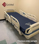 Refurbished Stryker S3 3002 in a clinic room with a blue mattress.