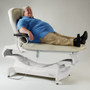 A patient reclining comfortably on a Ritter 244 bariatric power treatment table, showcasing the table’s sturdy support, armrests, and remote control operation.