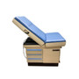 Midmark Ritter 404 exam table with light blue upholstery and beige base, shown in a semi-reclined position with three side drawers and pull-out stirrups.