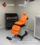 Midmark 641 refurbished with orange upholstery, and a foot control in a medical room.