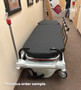 Refurbished Stryker 1061 in a clinic hallway with black mattress.