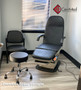 Refurbished Midmark 417 with black upholstery, foot control, and two matching stools in a clinic room.