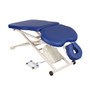 Blue Oakworks PT400M Physical Therapy Table with ergonomic cutouts, adjustable face cradle, and foot pedal control on a white metal scissor-lift base with wheels.
